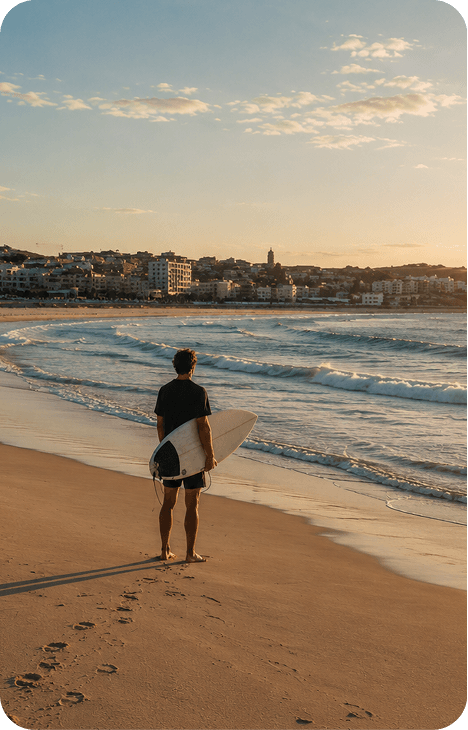 Surfer standing on an Australian beach at sunrise
